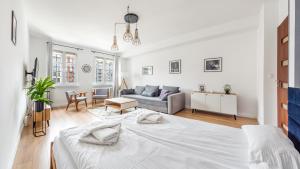 biała sypialnia z łóżkiem i kanapą w obiekcie Apartamenty Sun & Snow Old Town Gdańsk w Gdańsku