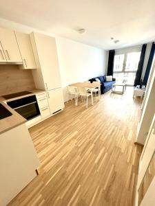 een keuken en een woonkamer met een houten vloer bij FORSTHAUS 27 FREE GARAGE in Wenen