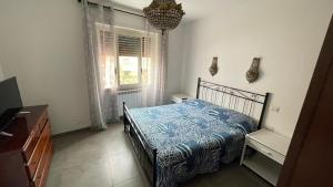 a bedroom with a bed with a blue blanket and a window at La casa di Mimma in Passoscuro