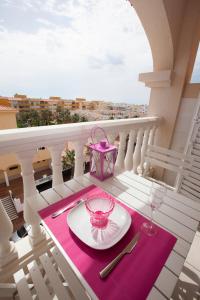 una mesa con un plato en el balcón con un mantel rosa en Beau studio meublé avec vue mer, en Almerimar