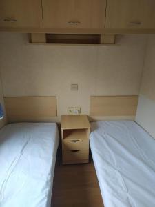a small room with two beds and a desk at Camping le val du ternois in Frévent