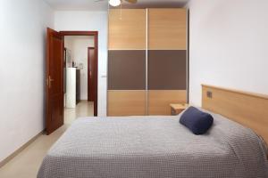a bedroom with a bed with a blue pillow on it at Cozy Apartment Costa del Sol in Torrox