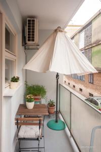 eine Terrasse mit einem Tisch und einem Sonnenschirm auf dem Balkon in der Unterkunft Luciana's city centre hideout in Zadar