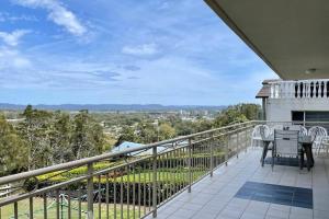 a balcony of a house with a table and chairs at Bennett's Bliss - Ocean View, 5 Bedrooms, 14 Guest in Forster