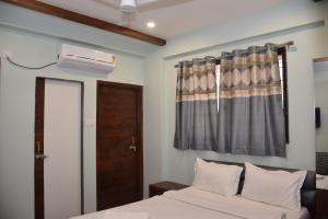a bedroom with a bed and a window with a air conditioner at Shankar Residency, Akkalkot in Akalkot +54 photos