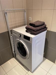 a washing machine with towels on top of it in a bathroom at Les Tuileries Eguisheim in Eguisheim