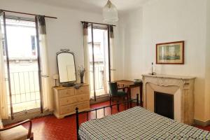 een slaapkamer met een bed, een open haard en een spiegel bij Tout le charme de l'ancien marseillais in Marseille