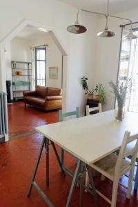 een woonkamer met een witte tafel en stoelen bij Tout le charme de l'ancien marseillais in Marseille