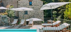 a group of chairs and umbrellas next to a pool at U Caseddu "studio" in Ortiporio