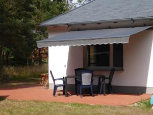 a patio with a table and chairs on a house at Ferienhaus Am Waldrand - "Libelle" in Tornitz