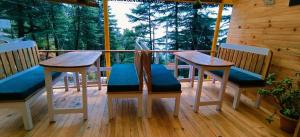 a porch with two tables and chairs on a deck at Mcleodganj Bed & Breakfast in McLeod Ganj