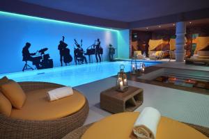a living room with a pool with a table and a couch at Aria Hotel Budapest by Library Hotel Collection in Budapest