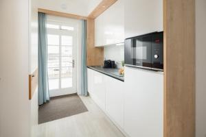 a kitchen with white cabinets and a microwave at Nordstrandperle Ap E4 in Norderney