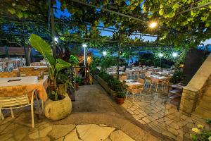 a restaurant with tables and chairs in a room at Apartments and Rooms Drago in Sveti Stefan