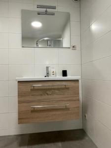 a bathroom with a sink and a mirror at Escape, appartement met groot terras in Buren