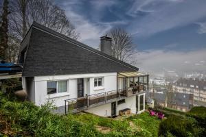 a white house with a balcony on a hill at Du haut des rives - Bel appt pour 4 in Caudebec-en-Caux