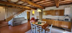eine Küche und ein Wohnzimmer mit einem Tisch und Stühlen in der Unterkunft Tenuta Colombaio in Casole dʼElsa