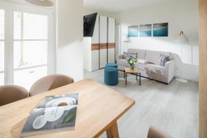 ein Wohnzimmer mit Tisch und Couch in der Unterkunft Nordstrandperle Ap H7 in Norderney