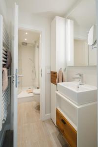 ein weißes Badezimmer mit Waschbecken und Toilette in der Unterkunft Nordstrandperle Ap H7 in Norderney