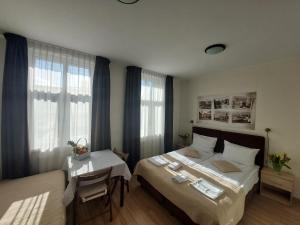 a bedroom with a bed and a table and windows at Willa Julia in Gdynia