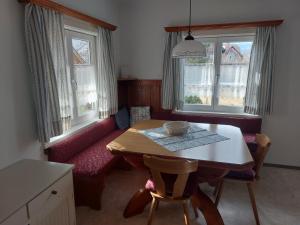 sala de estar con mesa y sofá rojo en Ferienwohnung Salzafeld, en Bad Mitterndorf