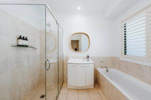 ein Badezimmer mit einer Badewanne, einem Waschbecken und einem Spiegel in der Unterkunft Ballantyne at Bombira - An Indulgent Country Escape in Mudgee