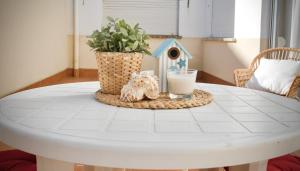 a white table with a bird house and a glass of milk at Casa Lamela in Villasante