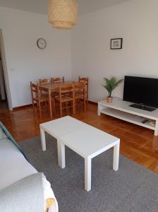 a living room with a table and a white coffee table at Ribeira Sacra O Saviñao in Villasante