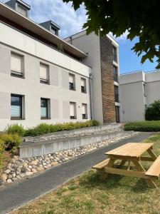 drewniany stół piknikowy przed budynkiem w obiekcie La petite tuilerie d Eguisheim w mieście Eguisheim