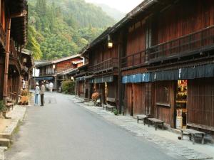 an empty street in a mountain village with buildings at Nukumorino-yado Komanoyu in Kiso