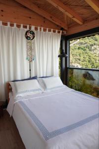 duże białe łóżko w pokoju z oknem w obiekcie SOAP LADY Hotel and More w mieście Muğla