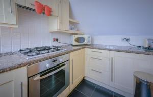 a kitchen with a stove and a microwave at Hunter Heights Apartment at Clevelands in Wroxall