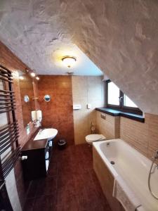 a bathroom with a tub and a sink and a toilet at Sári Csárda Panzió in Dunakiliti