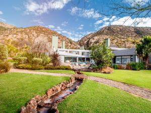an exterior view of a house with mountains in the background at Bophirima Boutique Hotel in Rustenburg