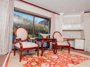 Duas cadeiras e uma mesa num quarto com uma janela em Bophirima Boutique Hotel em Rustenburg