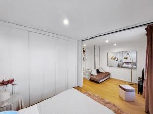 a bedroom with white walls and a room with a couch at Piazza di Spagna - Suite Donata, strollingrome in Rome