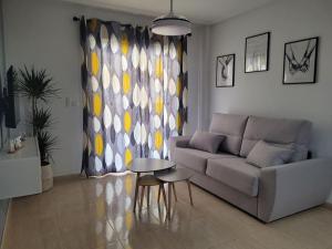 - un salon avec un canapé et une table dans l'établissement Elegante piso con terraza, garaje, piscina y AC, à El Campello