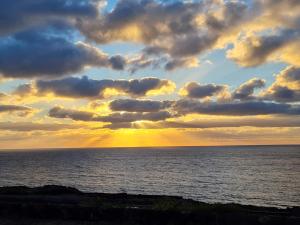 um pôr-do-sol sobre o oceano com nuvens no céu em Dammuso Sul mare MDQ Sea em Pantelleria
