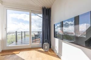 a bedroom with a large window with a view of the ocean at Arlau Schleuse - Schleuse twee in Hattstedtermarsch