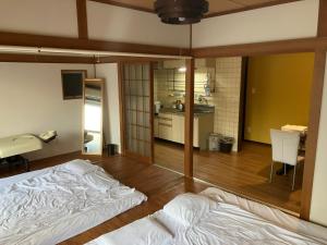 a room with two beds in it with a kitchen at Casa Viento Stay Inn in Hiroshima