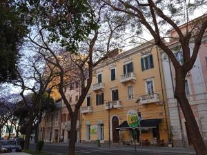 un edificio giallo su una strada cittadina alberata di Casa jacaranda a Cagliari