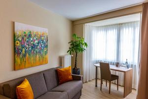 a living room with a couch and a table with a painting at Hotel Kronenhof in Schaffhausen