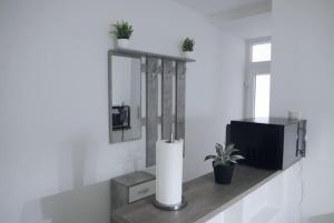 ein Regal mit einer Kerze und einem Fernseher darauf in der Unterkunft Stilvolle Wohnung in Wuppertal inkl. Kaffee & Tee in Wuppertal