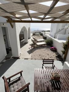 eine Terrasse mit einer Holzbank und einem Tisch in der Unterkunft The Vine Suites in Vourvoúlos