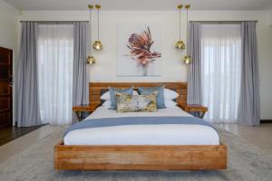 a bedroom with a large wooden bed with pillows at 11 on Fairway Beach Villa in Southbroom