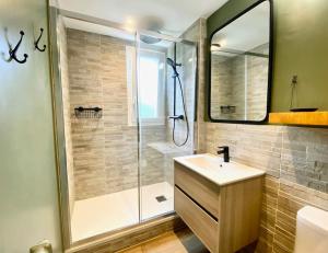 a bathroom with a shower and a sink and a mirror at Pluton - SILS in Caen