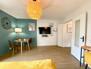 Cette chambre comprend un lit, une table et une horloge. dans l'établissement Pluton - SILS, à Caen