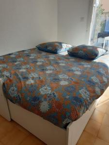 un letto con due cuscini sopra di Studio 4 personnes avec jardinet à 2 pas des plages "Chez Manon" a Carro