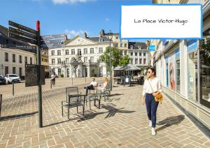 Une femme marchant dans une rue d'une ville dans l'établissement Le Moment Détente - Appartement avec balnéothérapie, à Saint-Omer