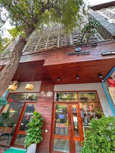 a store front with glass doors and a tree at Monsoon Riverside Hotel in Phnom Penh